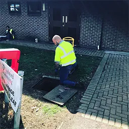 man holding pipe down drain